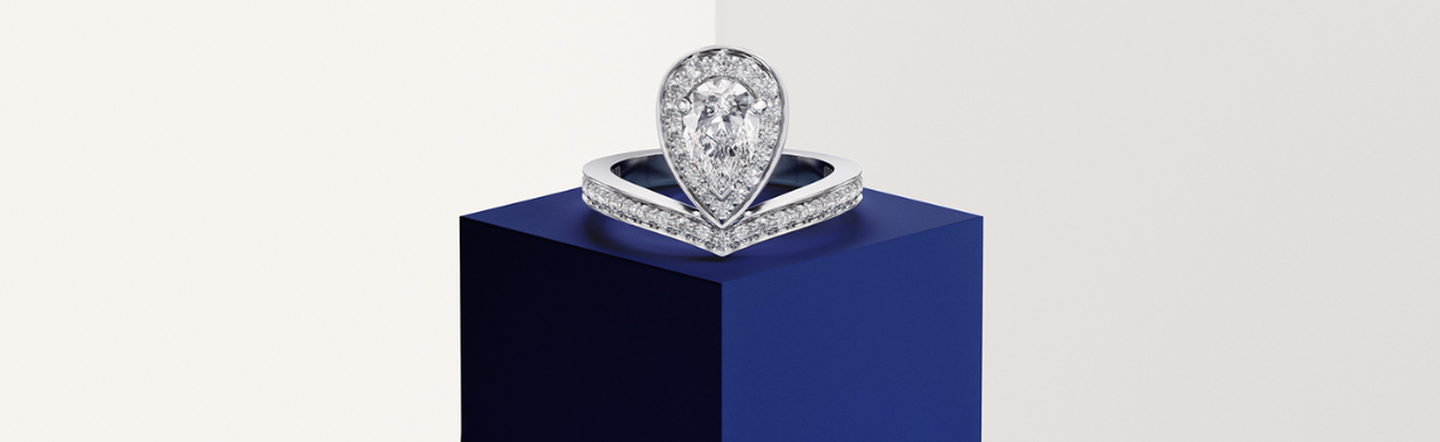 A Chaumet Jos&eacute;phine diamond engagement ring on a dark blue background.